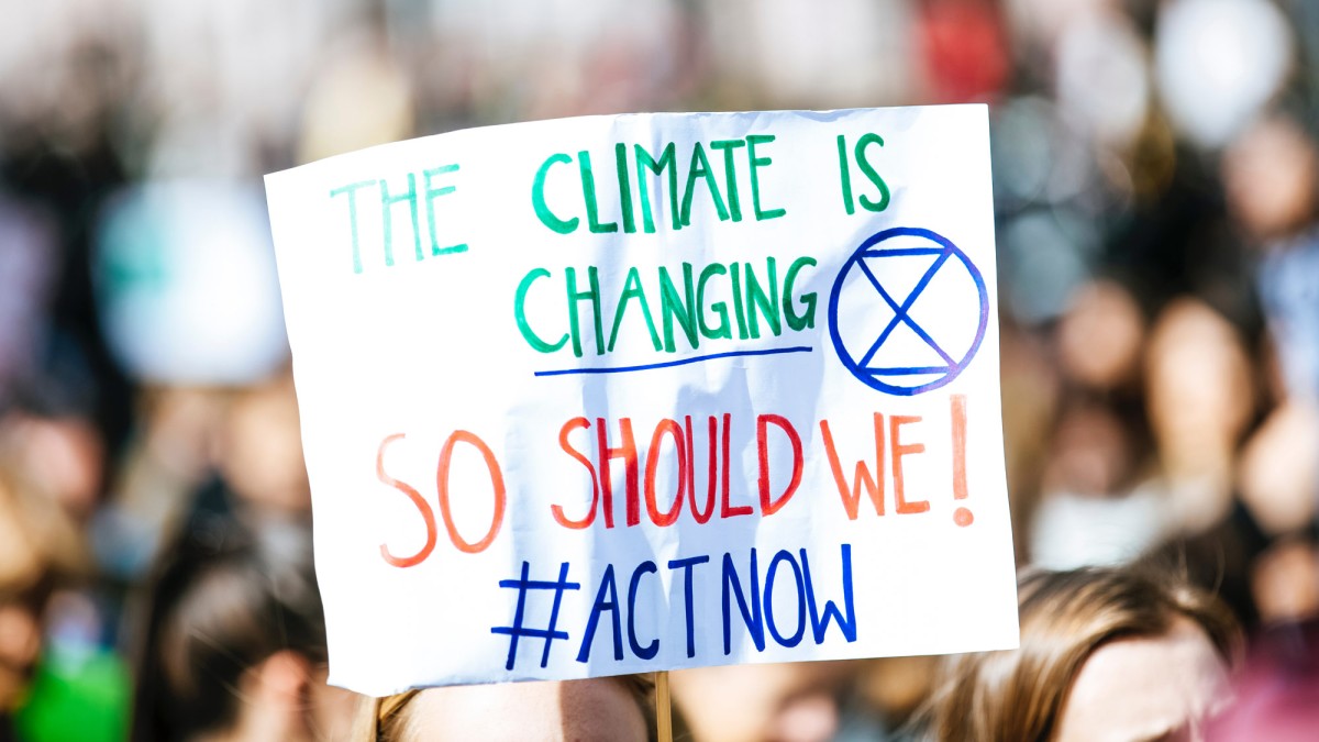 Schild mit Aufschrift "The Climate ist changing so should we! #actnow"